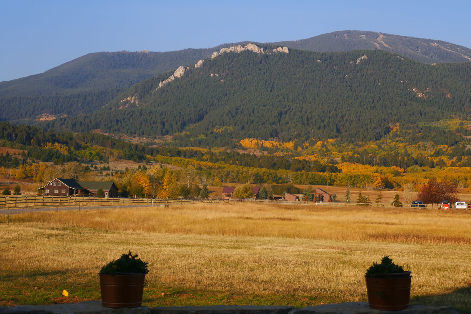 Mountain landscape with fields and distant houses.