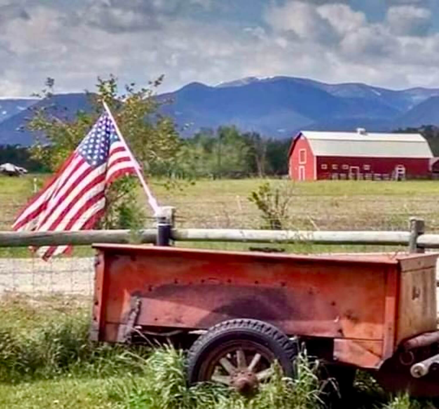 American flag and barn in rural landscape.